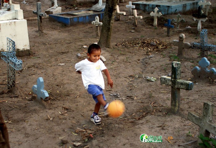 薩爾瓦多的孩子馬科斯·巴里奧斯圍繞著墓碑踢足球